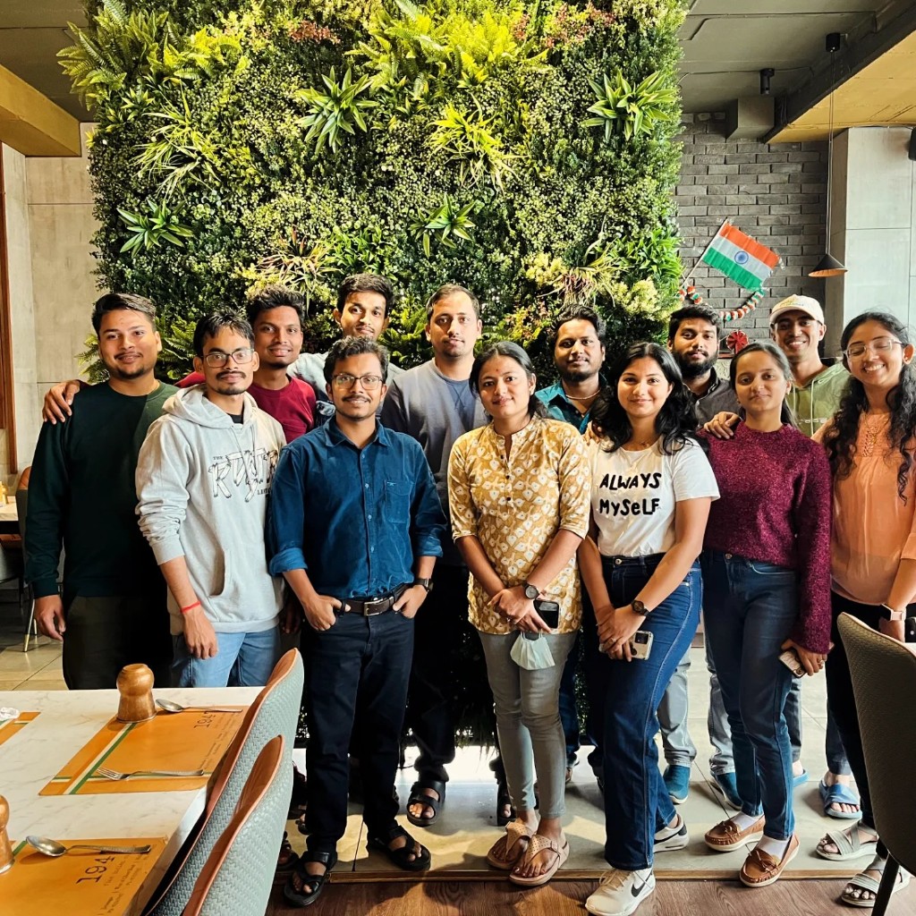 WhatsTool team photo in front of a green living wall