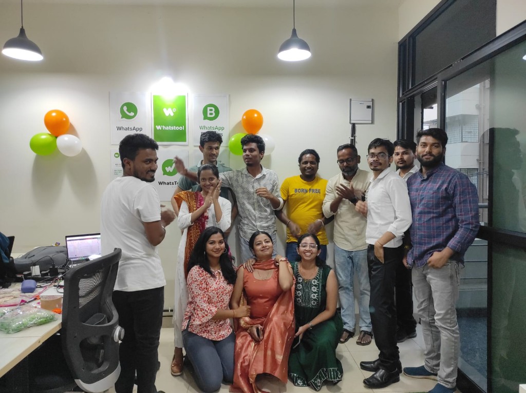 Team celebration in the office with WhatsApp and WhatsTool branding